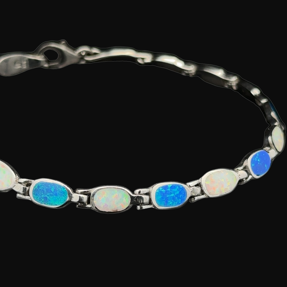 
                  
                    The Oval Lab-Created Opal Bracelet, crafted with .925 Sterling Silver, exudes modern elegance with its oval lab-created opal stones elegantly set along the band.
                  
                