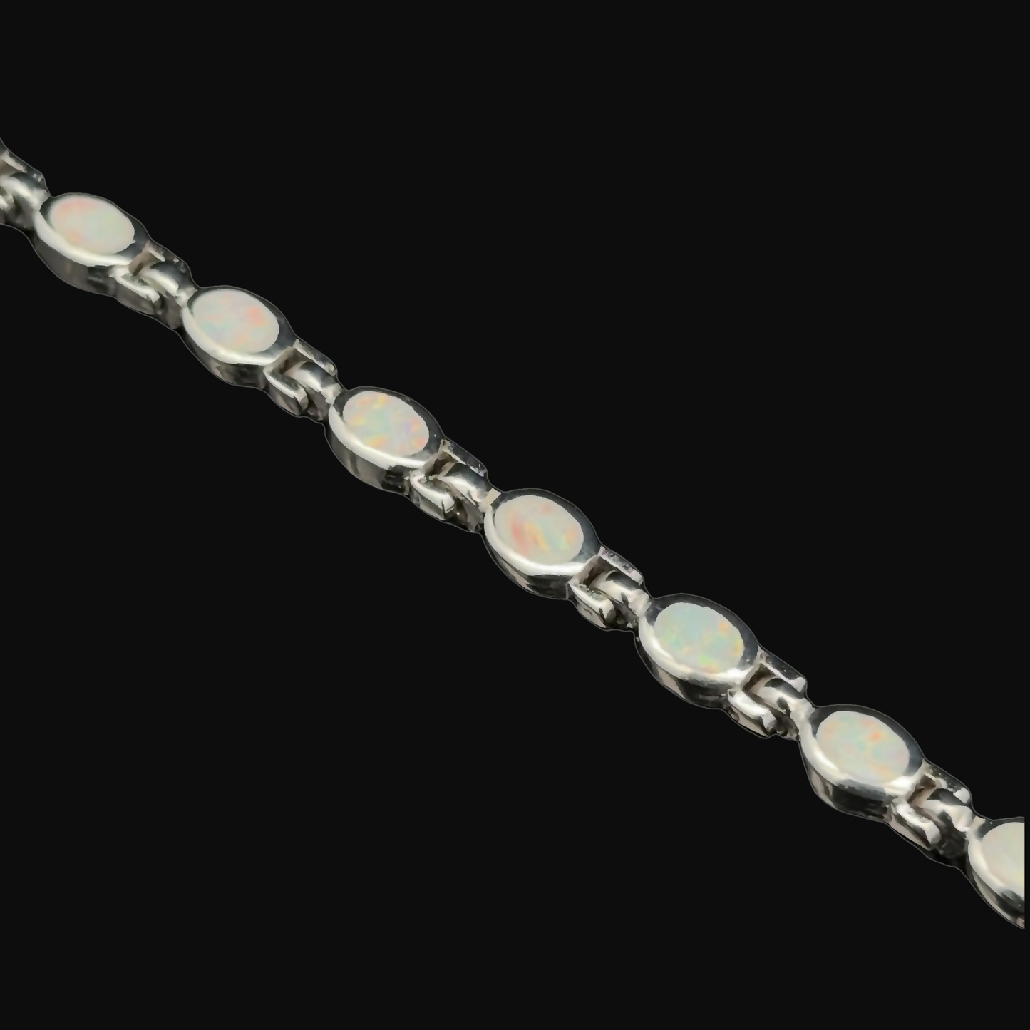 
                  
                    The Oval Lab-Created Opal Bracelet, consisting of multiple oval lab-created opal stones linked together against a black background, is an elegant piece of jewelry that is sure to captivate.
                  
                