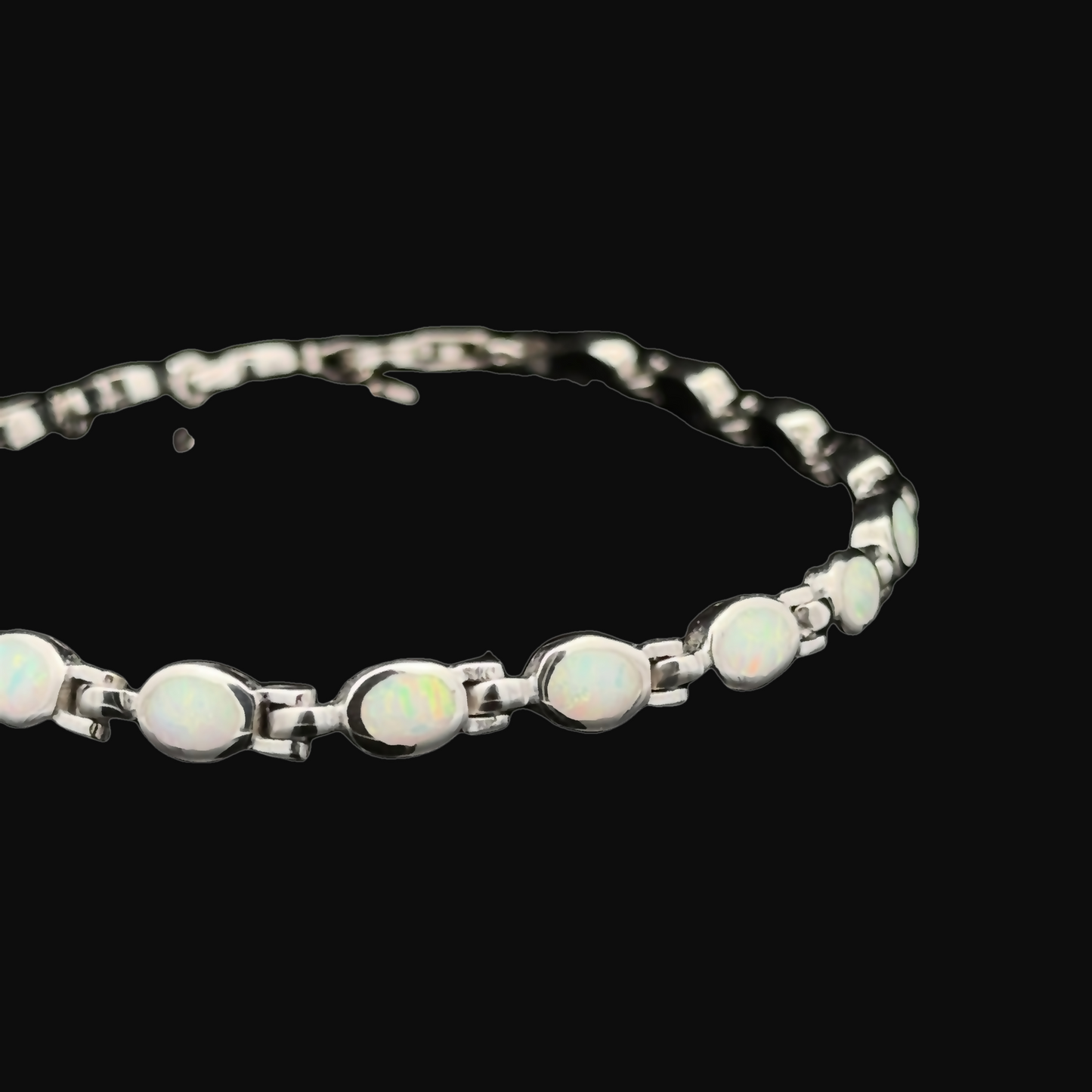 
                  
                    The Oval Lab-Created Opal Bracelet, crafted from sterling silver and featuring oval white lab-created opal gemstones in a modern design, is displayed on a black background.
                  
                