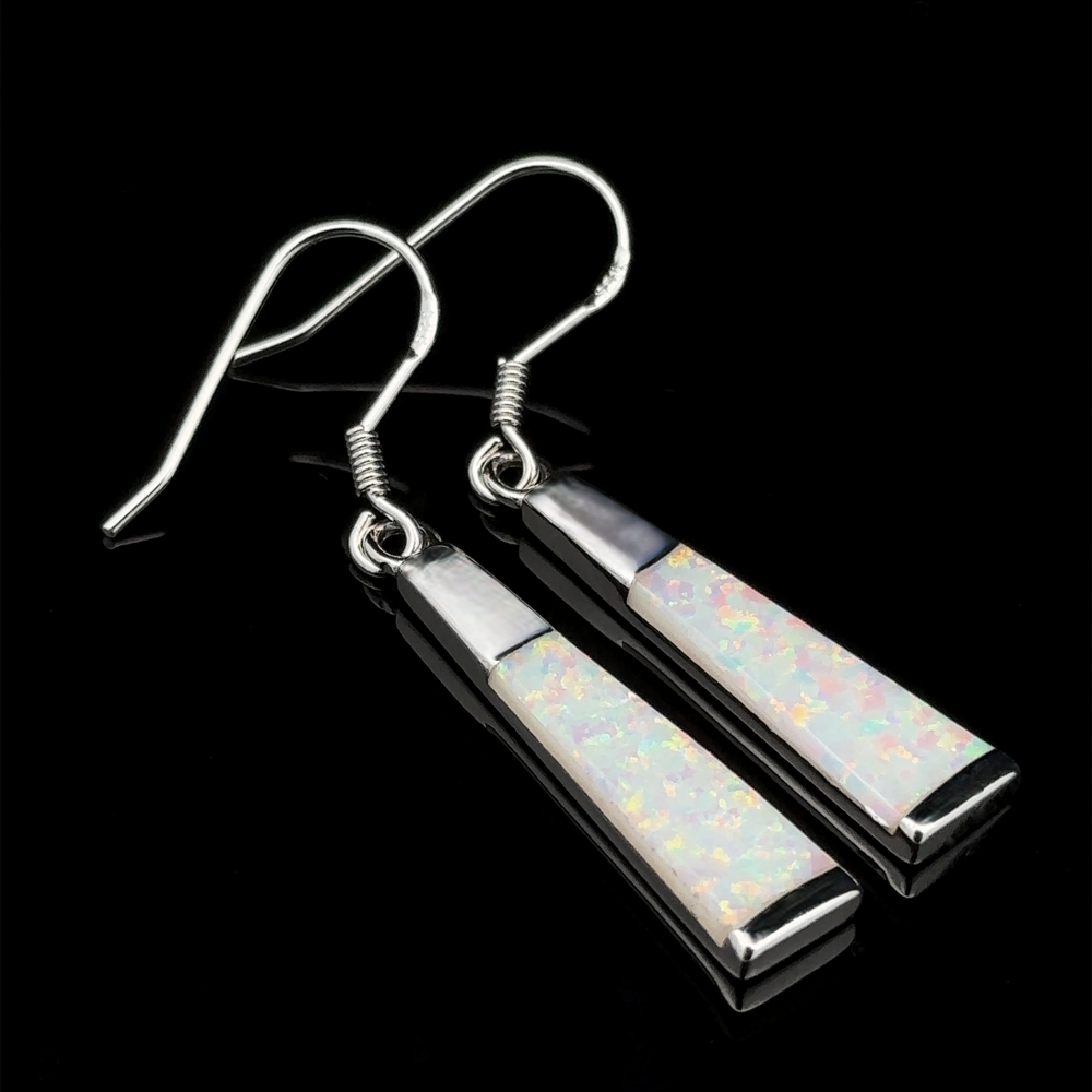 
                  
                    These Elegant Long Opal Earrings exude modern elegance with their elongated flared rectangle shapes and lab-created opal inlays set against a sleek black background.
                  
                