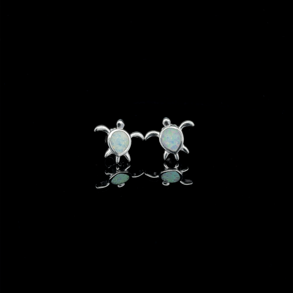 
                  
                    Pair of Simple Lab-Created Opal Turtle Studs in sterling silver, elegantly displayed on a reflective black surface.
                  
                