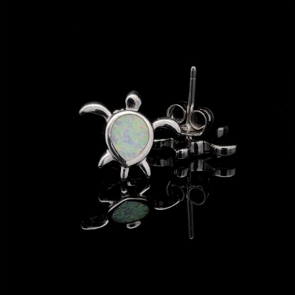 
                  
                    A pair of Simple Lab-Created Opal Turtle Studs in sterling silver, showcased on a black reflective surface.
                  
                