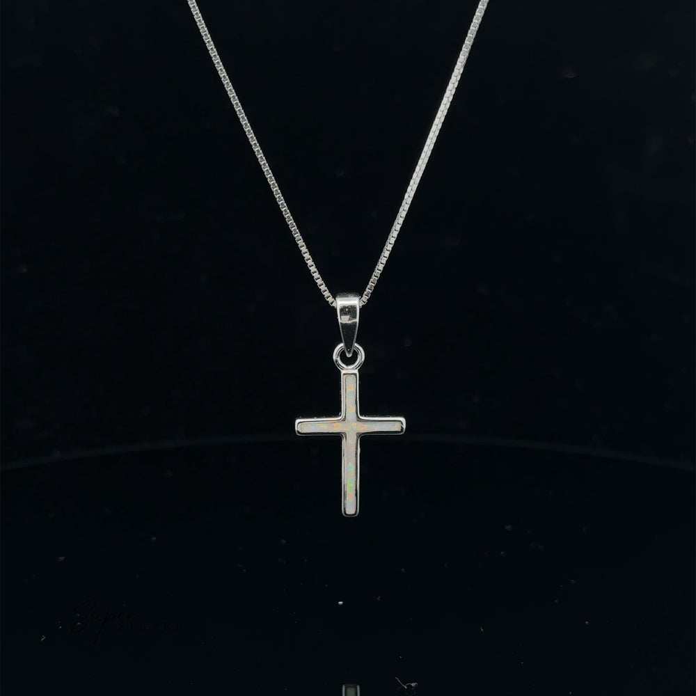 
                  
                    The Lab-Created Opal Cross Pendant gracefully suspended on a delicate chain against a black background showcases the enduring appeal of sterling silver jewelry.
                  
                