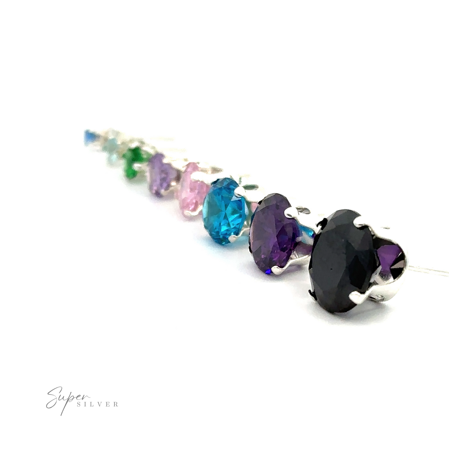 A row of colorful, teardrop-shaped Round CZ Studs arranged in a gradient on a white background.