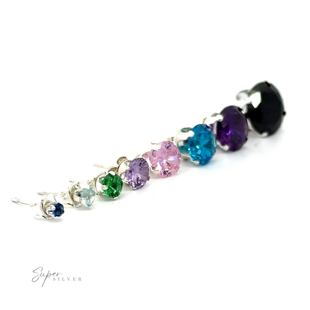 A line of assorted colorful Round CZ studs on a white background.