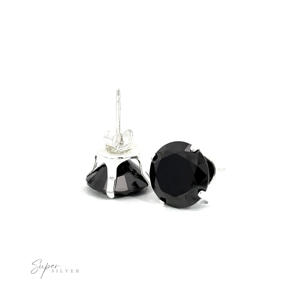
                  
                    A pair of black round CZ stud earrings on a white surface.
                  
                