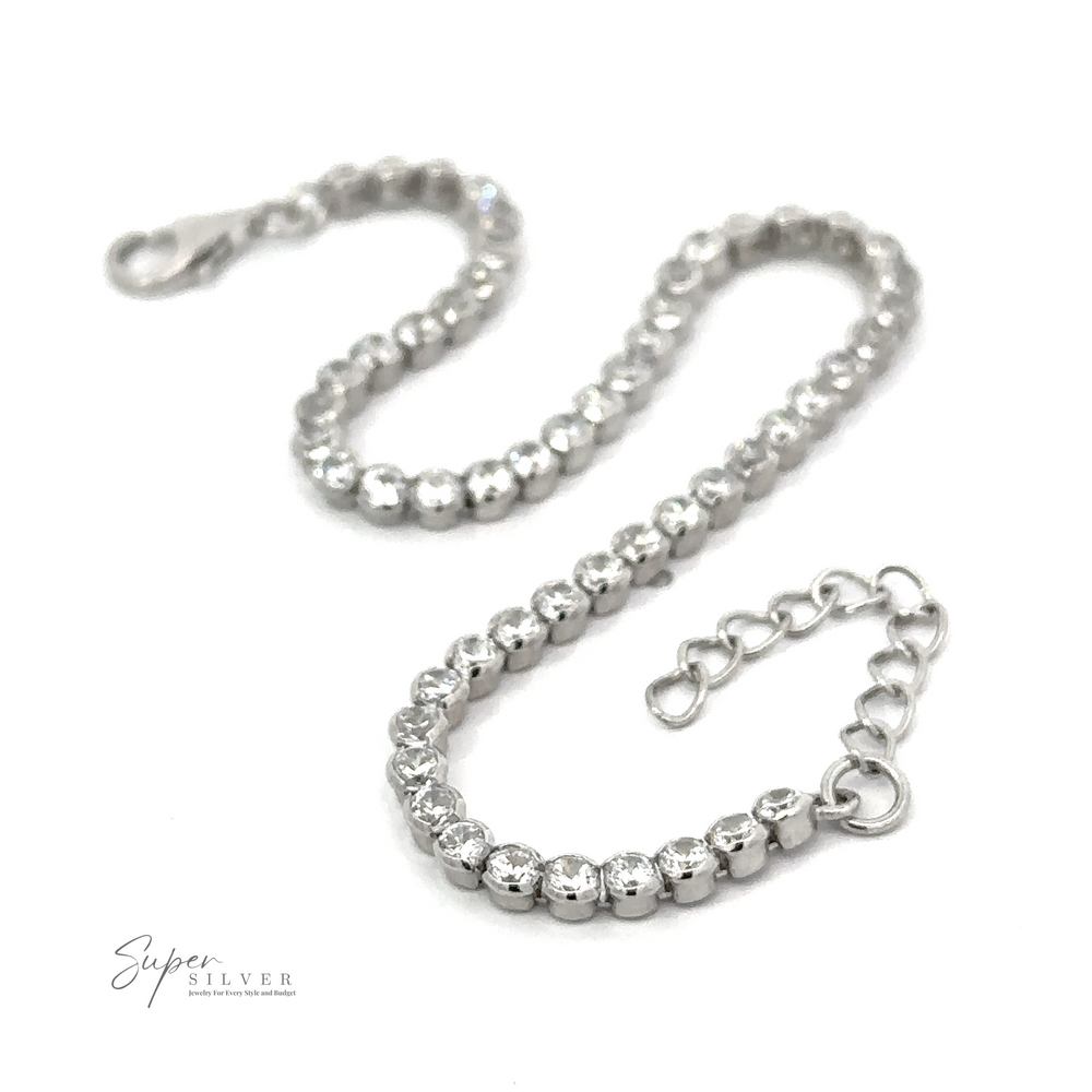 A Round Cubic Zirconia Tennis Bracelet with a clasp, featuring a series of linked, round beads and laid out flat on a white background. The logo 