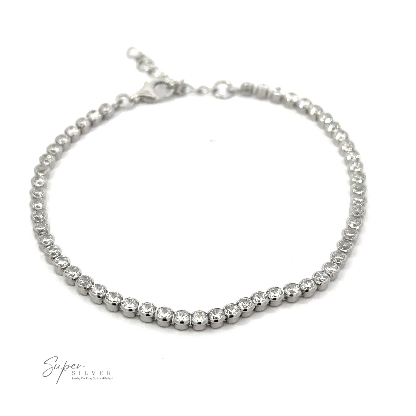 
                  
                    A Round Cubic Zirconia Tennis Bracelet adorned with round cubic zirconia gemstones arranged in a row. The dainty accessory features a clasp at one end and is displayed against a plain background. The logo "Super Silver" is visible in the corner.
                  
                