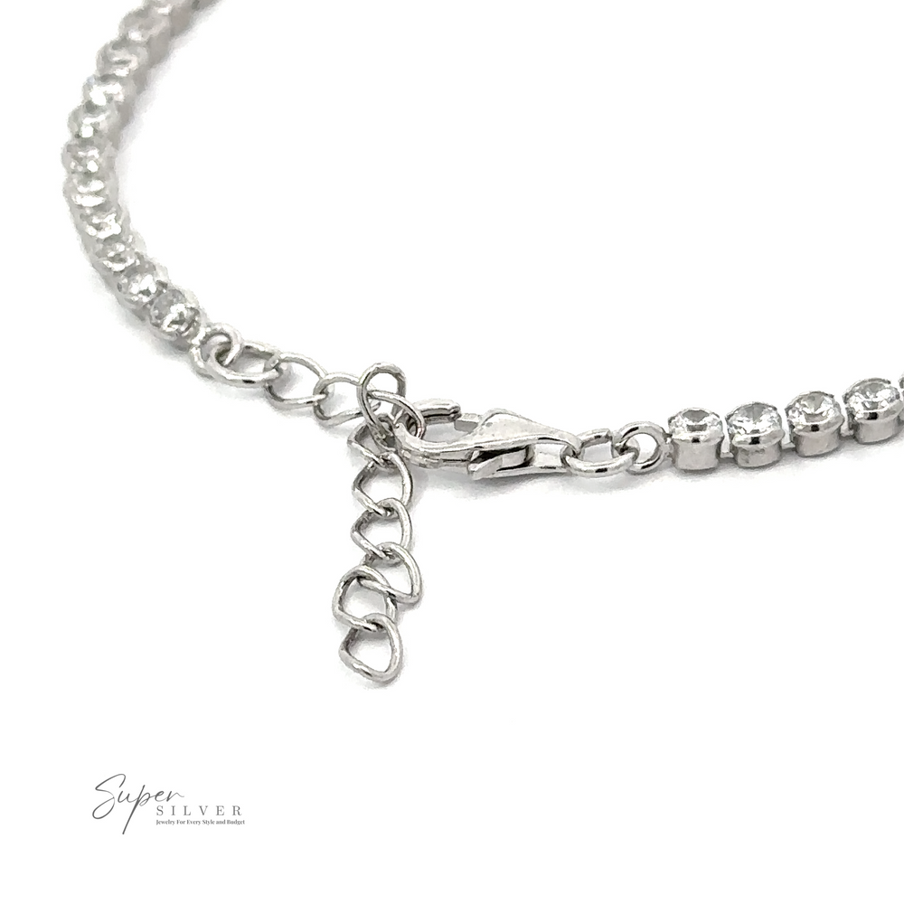 
                  
                    Close-up of a Round Cubic Zirconia Tennis Bracelet with a lobster clasp and extension chain, featuring rhinestones along its length. The brand name "Super Silver" is visible in the bottom left corner.
                  
                
