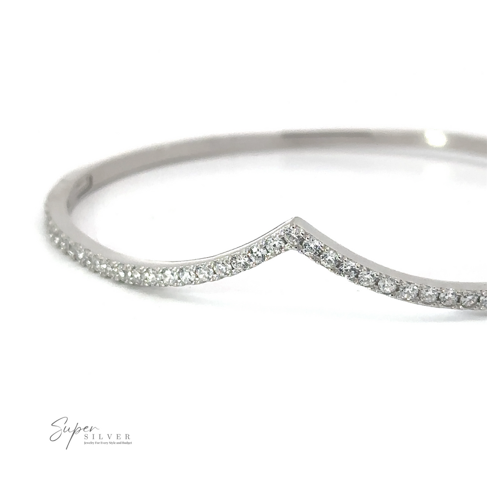 A thin, rhodium plated sterling silver bracelet with a v-shaped curve in the center, adorned with small, sparkling crystals. This elegant Cubic Zirconia Chevron Latch Bracelet features the logo 