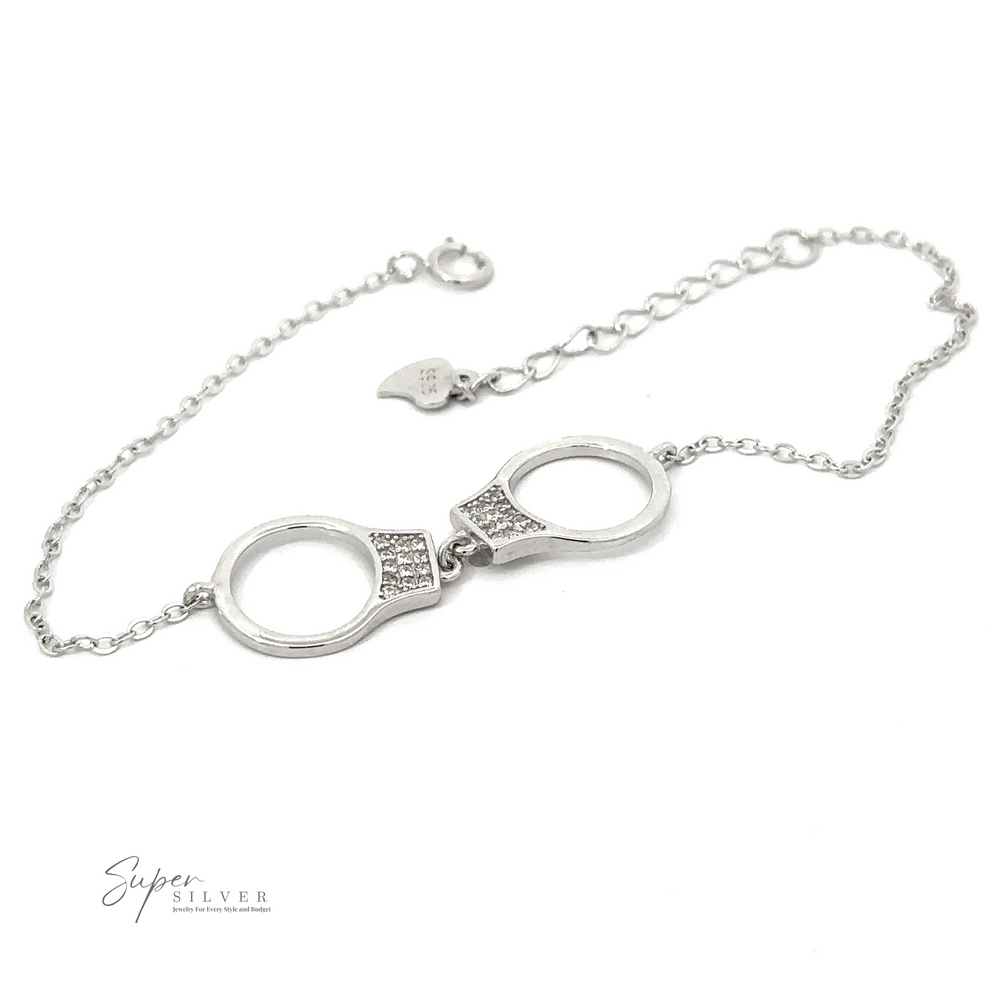 A Delicate Cubic Zirconia Handcuff Bracelet with small handcuff-shaped links and an adjustable chain, featuring the brand name 