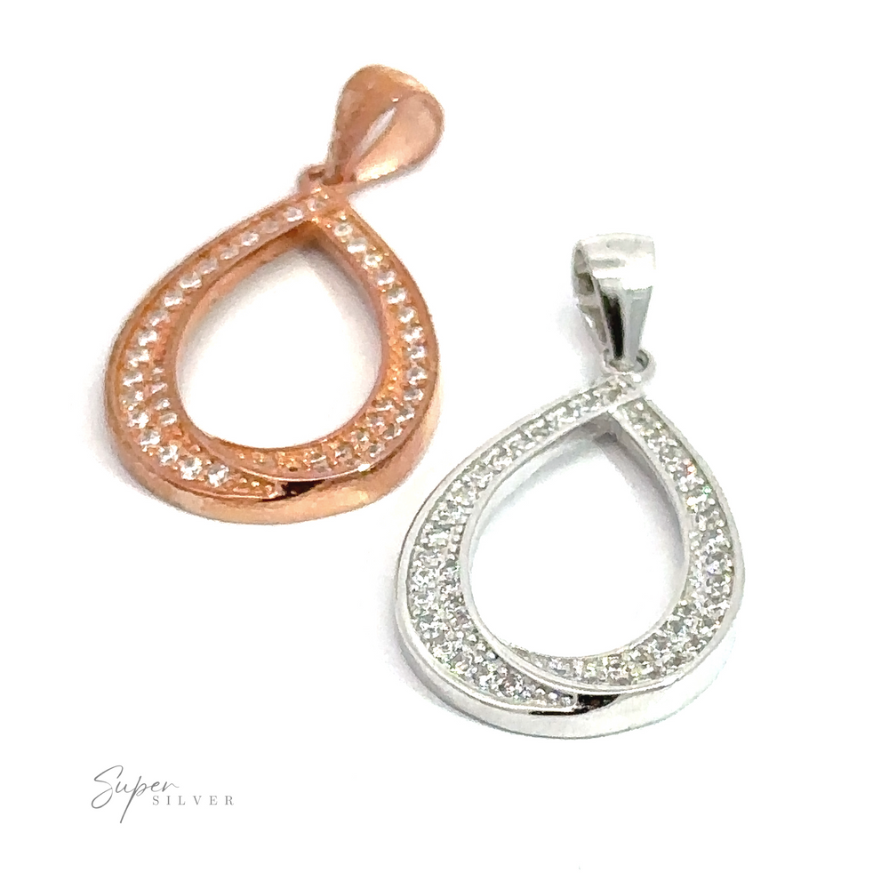 
                  
                    Two Teardrop Shape Cubic Zirconia Pendants, one in rose gold and the other in rhodium-plated sterling silver, both encrusted with small crystals, placed on a white background.
                  
                