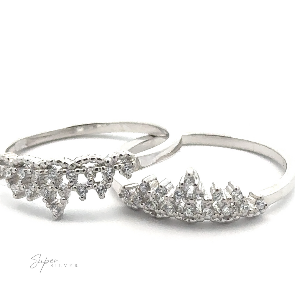 
                  
                    Two "Dainty Cubic Zirconia Crown Rings" featuring intricate, jagged designs and adorned with small, sparkling cubic zirconia stones are positioned side by side on a white background. The logo "Super Silver" is visible in the bottom left corner.
                  
                