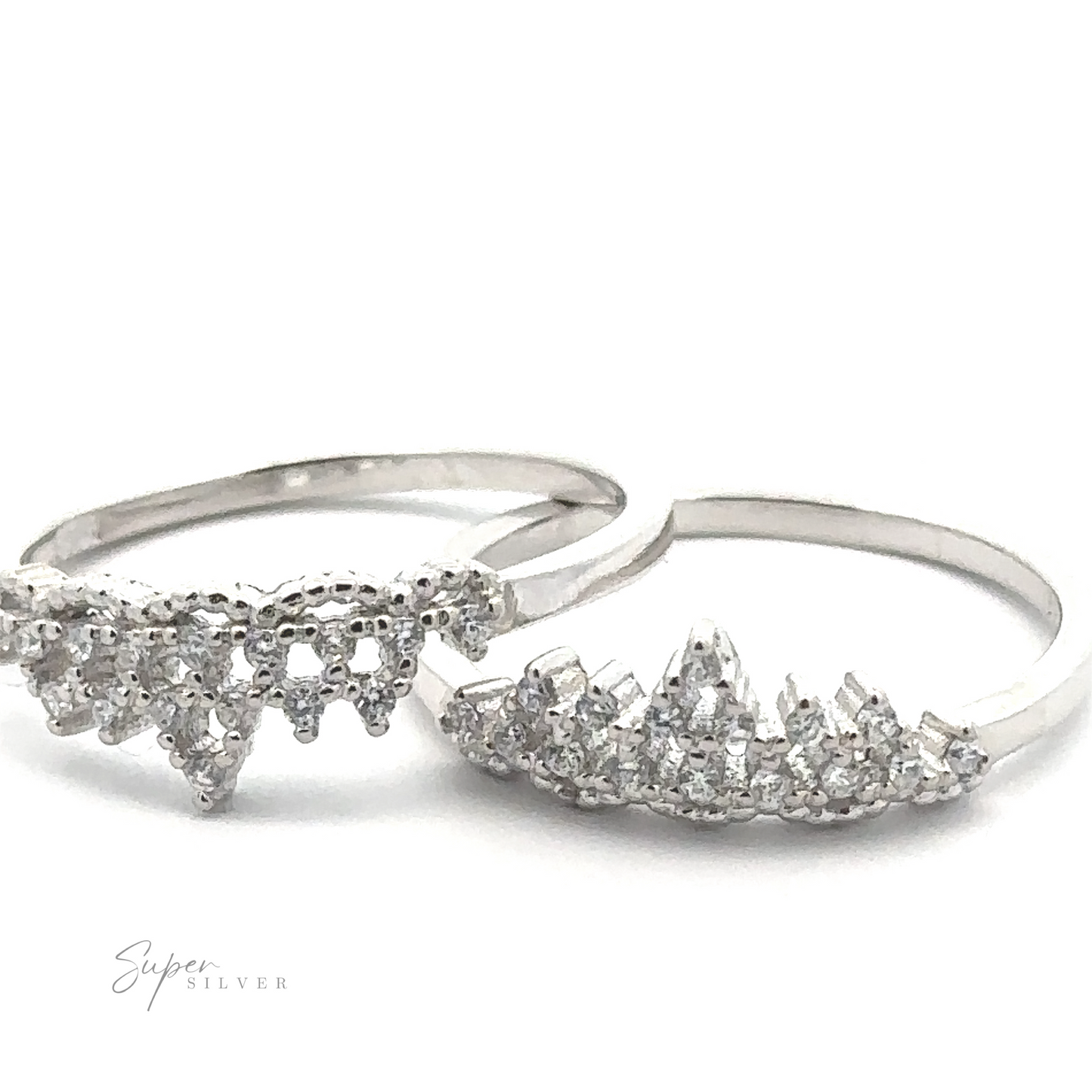 Two "Dainty Cubic Zirconia Crown Rings" featuring intricate, jagged designs and adorned with small, sparkling cubic zirconia stones are positioned side by side on a white background. The logo "Super Silver" is visible in the bottom left corner.