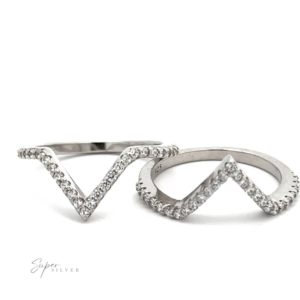 Two silver rings with a chevron design, encrusted with small clear stones in a vintage French pave style, displayed on a white background. 