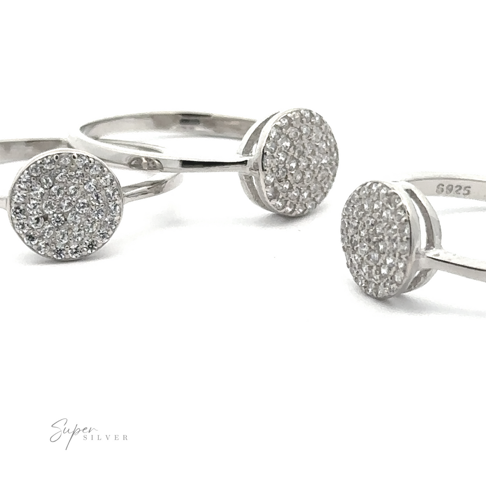 
                  
                    Three Round Pave Cubic Zirconia Rings made of sterling silver are positioned against a plain white background. One of the rings displays the engraving "G925." The "Super Silver" logo is visible in the bottom left corner, showcasing the exquisite rhodium finish.
                  
                