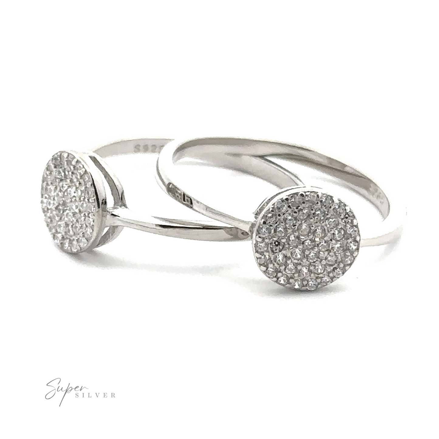 Two "Round Pave Cubic Zirconia Rings" with circular, diamond-studded tops are displayed on a white background, showcasing a minimalist design and sparkling gems. The brand name "Super Silver" is visible in the corner, highlighting the sophistication of these rhodium finish pieces.