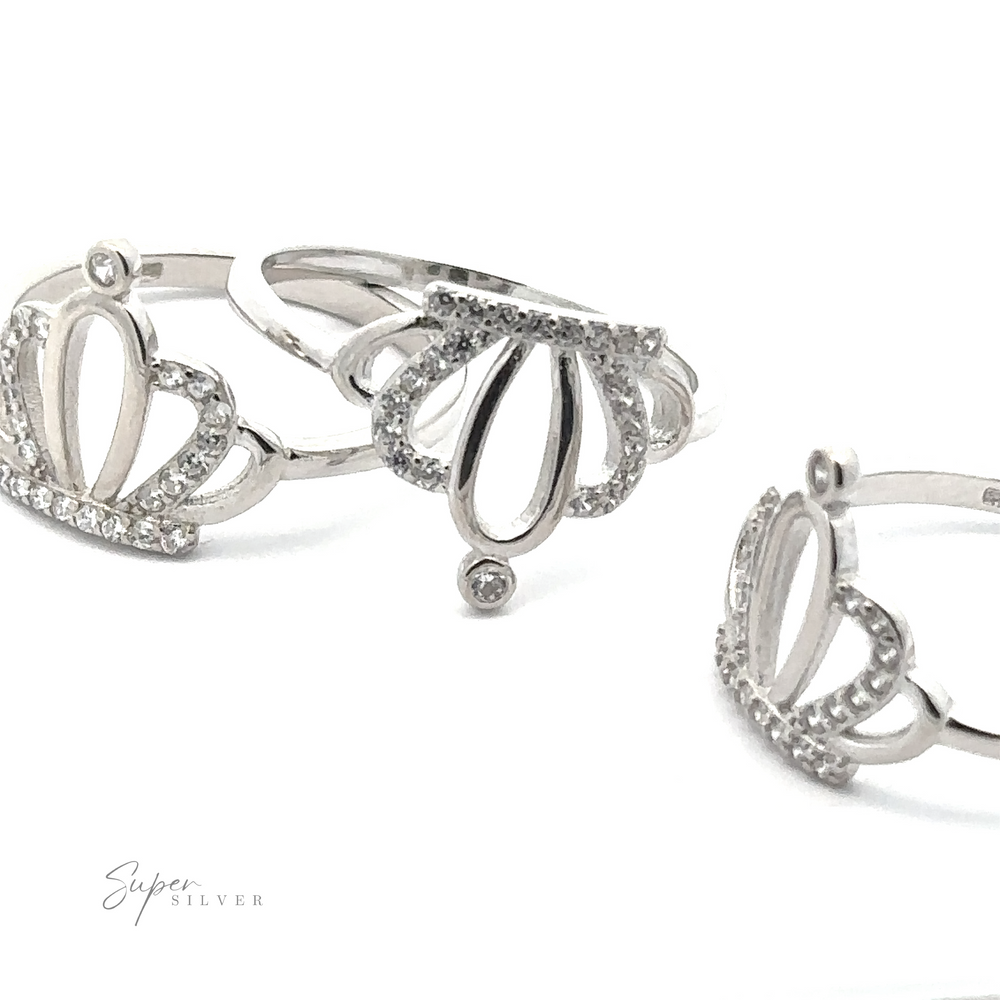 
                  
                    Three Cubic Zirconia Crown Rings, each made of sterling silver and adorned with small cubic zirconia stones, arranged in a close-up shot on a white background.
                  
                