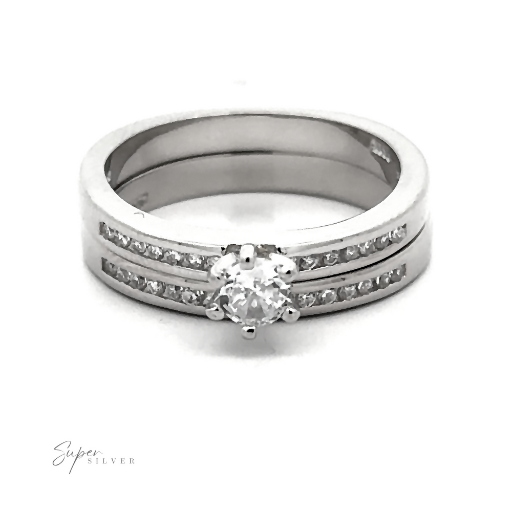 
                  
                    A Brilliant Round Cubic Zirconia Wedding Ring Set with rhodium finish, featuring a large central diamond flanked by two rows of smaller diamonds on the band. The Super Silver logo is visible in the bottom left corner.
                  
                