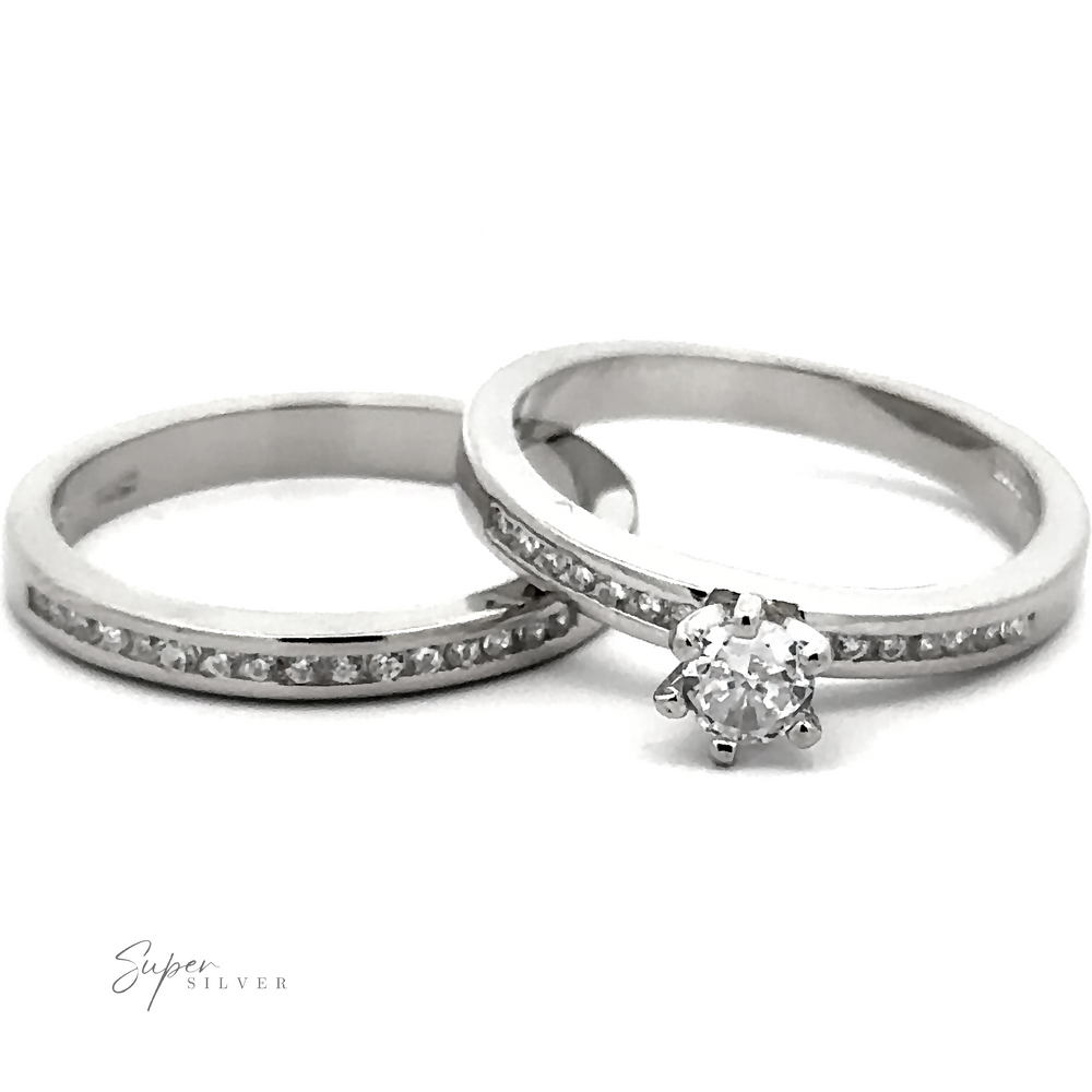 Two sterling silver rings: one with a solitaire diamond and the other, a round stone wedding band studded with Cubic Zirconia. Both rings are branded 