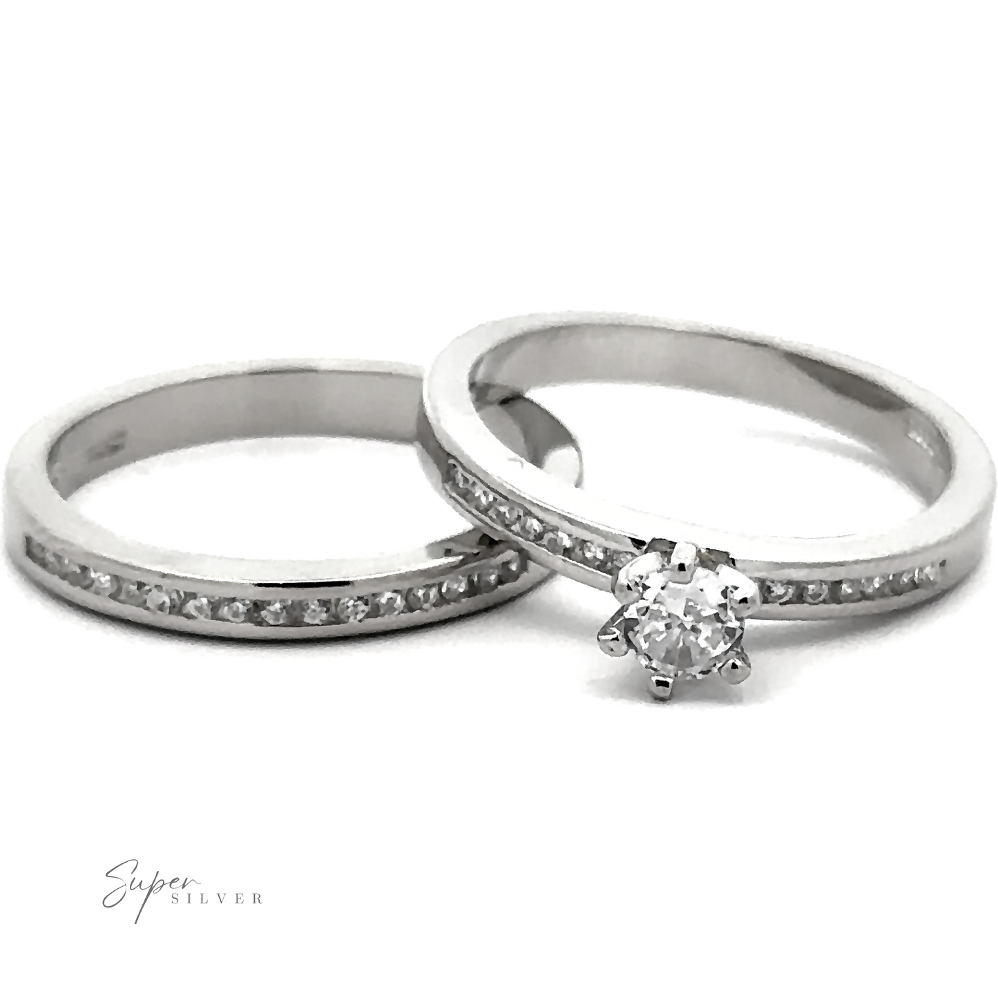 Two sterling silver rings: one with a solitaire diamond and the other, a round stone wedding band studded with Cubic Zirconia. Both rings are branded "Brilliant Round Cubic Zirconia Wedding Ring Set.