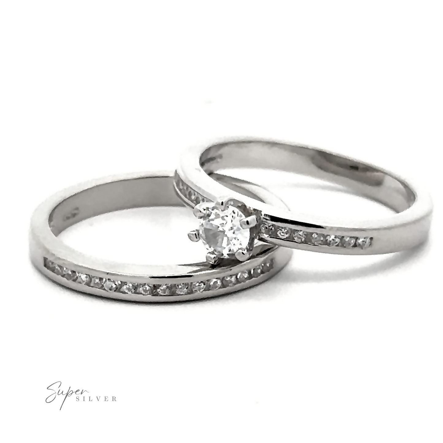 Two sterling silver rings are shown. One features a solitaire cubic zirconia, while the other, a Brilliant Round Cubic Zirconia Wedding Ring Set, has smaller diamonds set into the rhodium finish band.