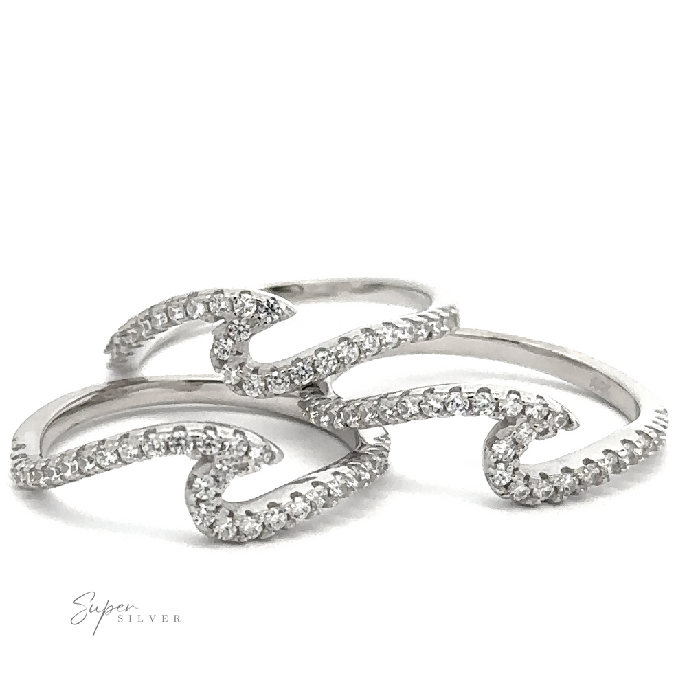 
                  
                    Three intertwined sterling silver rings with a wave design, each adorned with small cubic zirconia. The logo "Pave Wave Ring" appears in the lower left corner.
                  
                