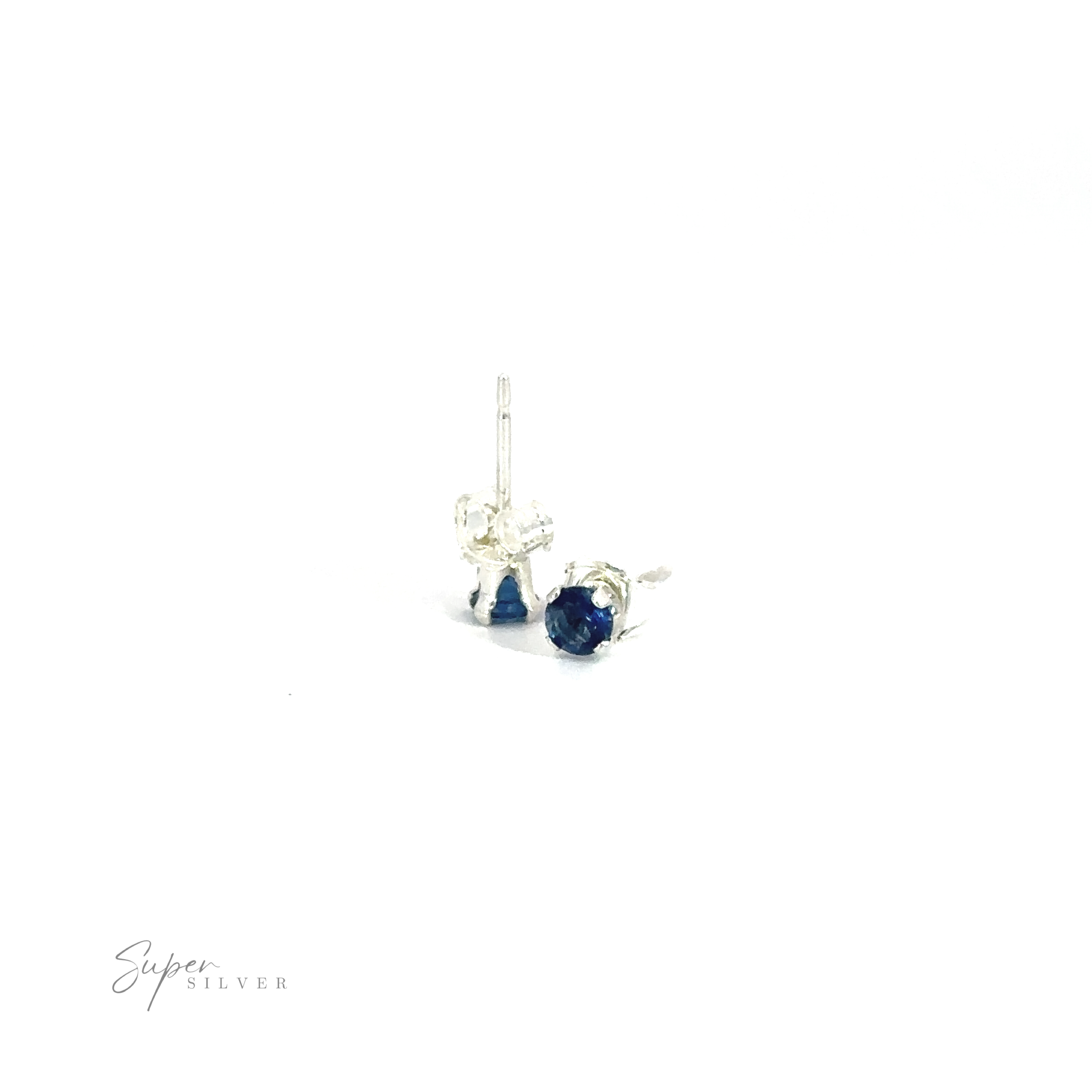 A pair of Round CZ Studs with blue cubic zirconia gemstones on a white background.