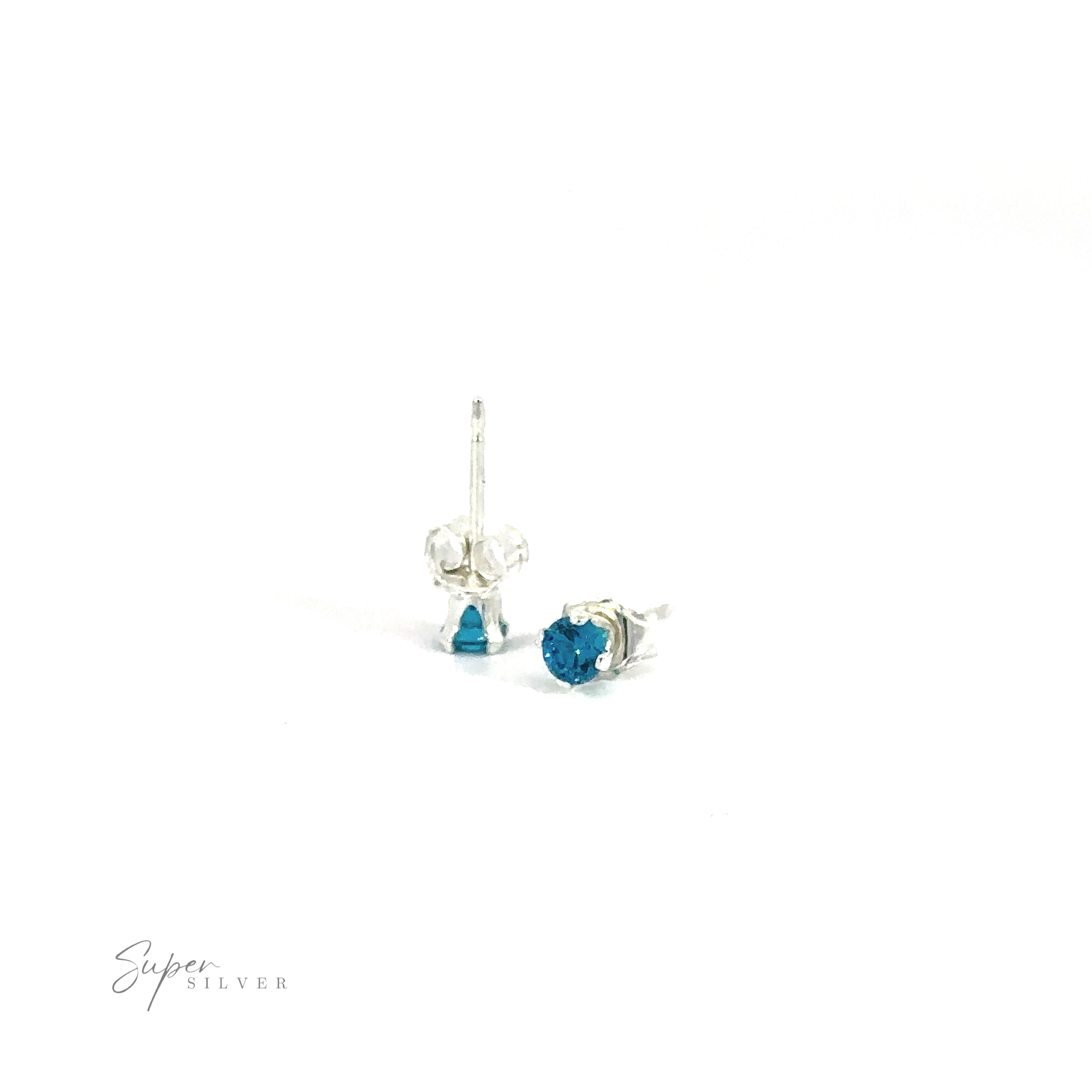 A pair of blue Round CZ stud earrings on a white background with a signature at the bottom.