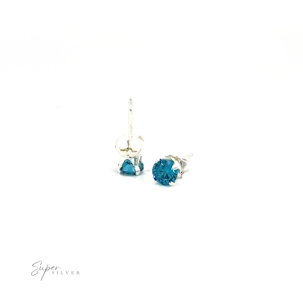 
                  
                    Pair of silver Round CZ studs with blue cubic zirconia on a white background.
                  
                