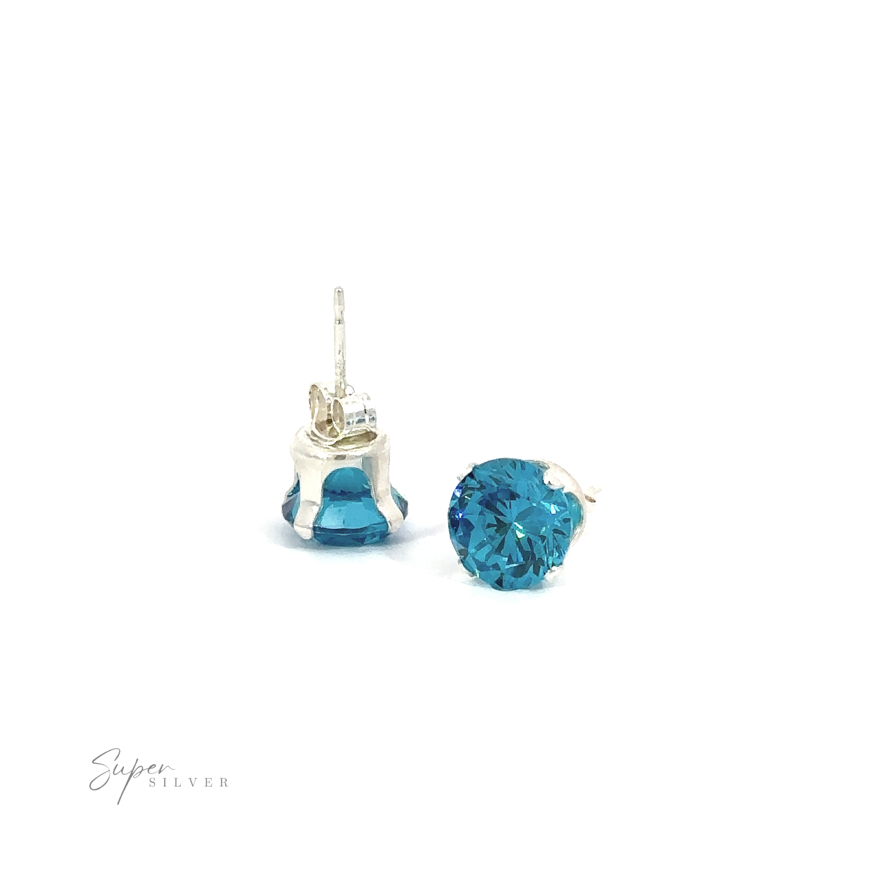 A pair of blue Round CZ Studs with one upright and the other lying on its side against a white background.