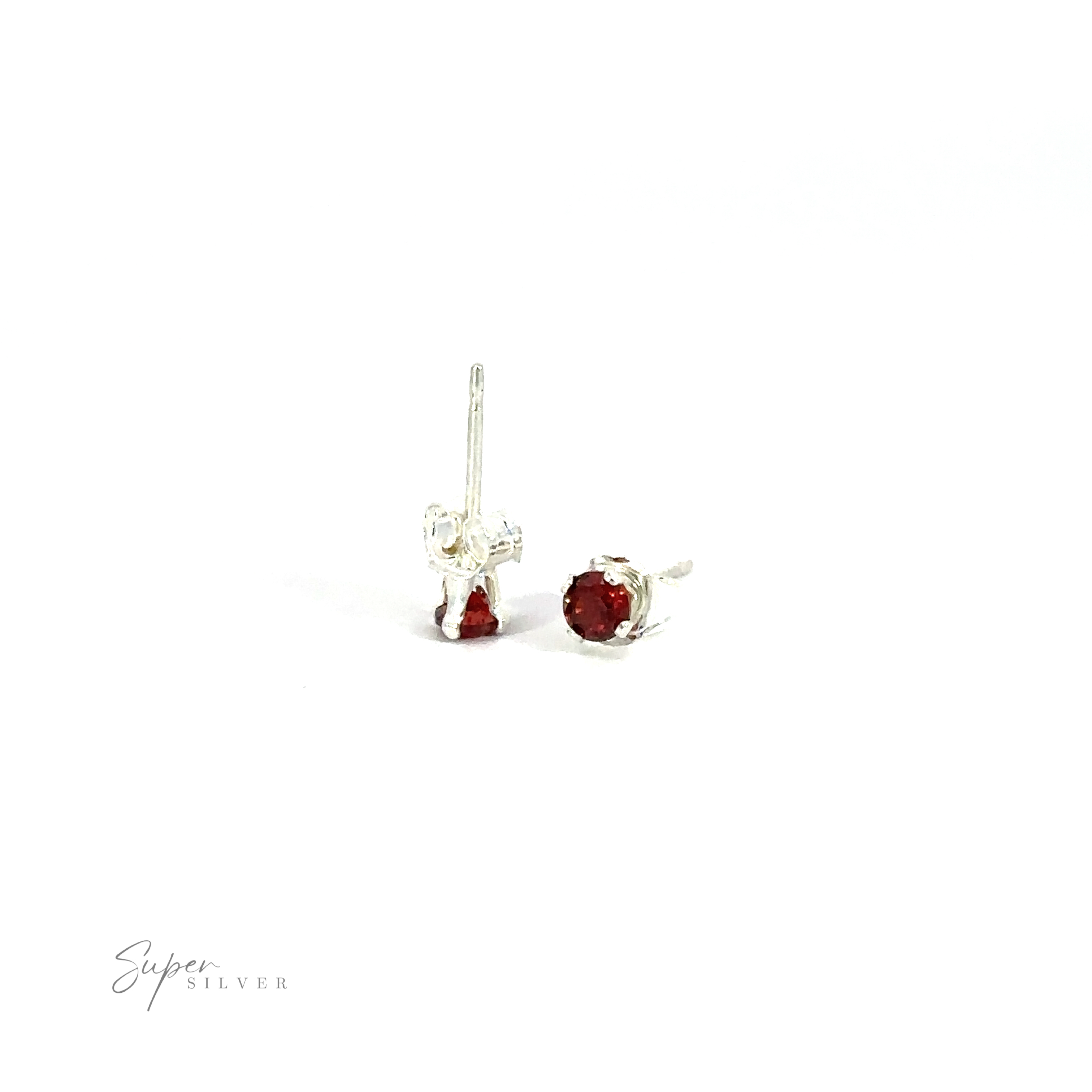 A pair of versatile Round CZ Studs with red cubic zirconia gemstones against a white background.