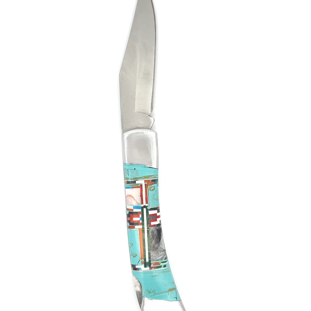 
                  
                    The Intricate Inlay Southwest Pocket knife features a shiny metal blade and a decorative handle adorned with turquoise, red, and white patterns in a Southwest style.
                  
                