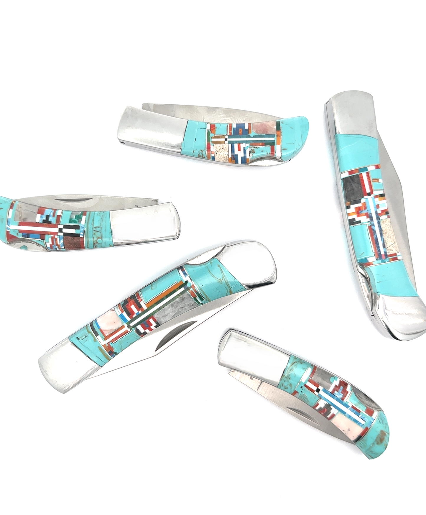 A selection of five Southwest-style pocket knives, each featuring intricate turquoise and red inlay designs on the handles, are arranged randomly on a white background.