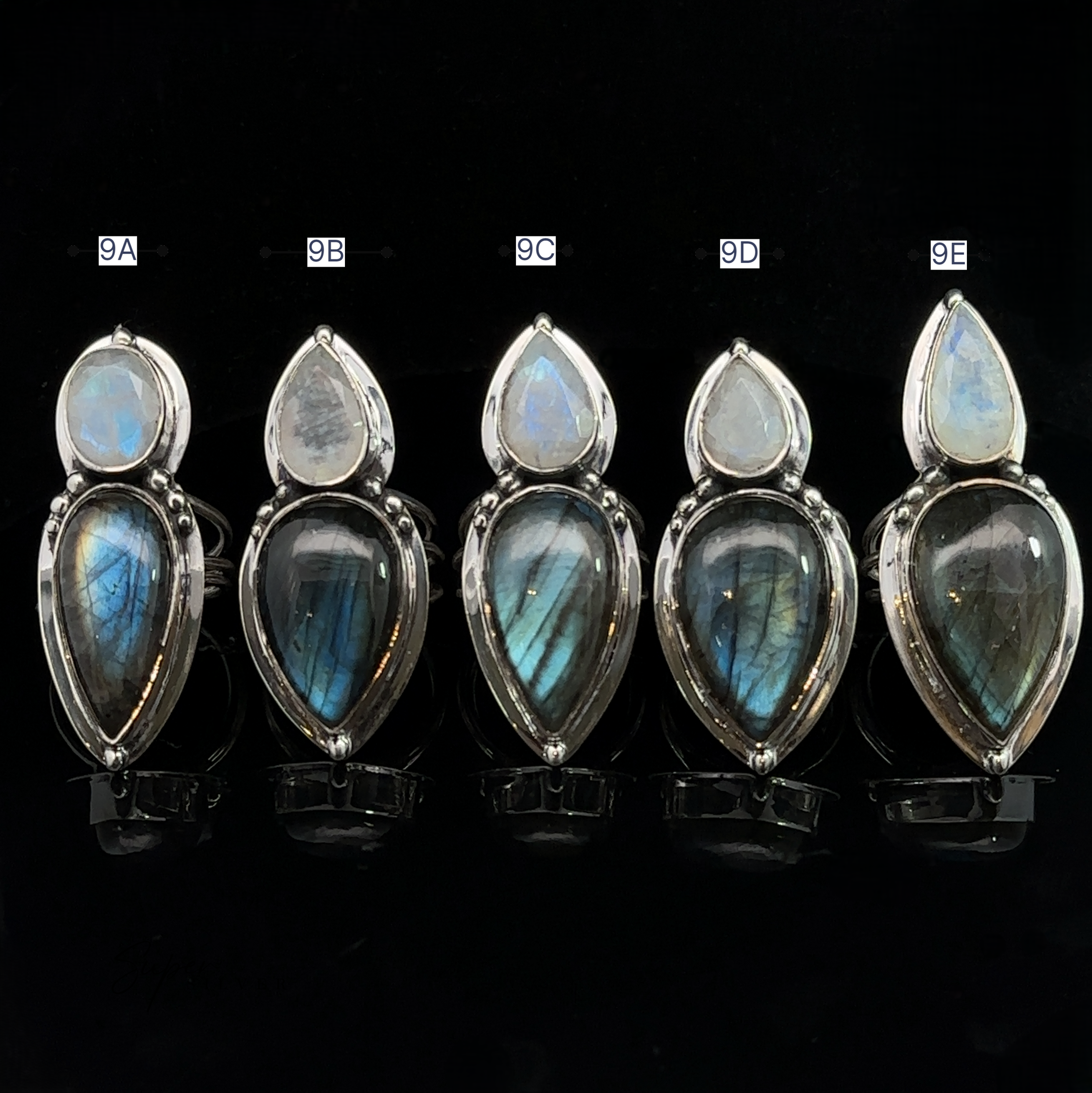 Five Heavy Labradorite And Moonstone Rings, labeled 9A to 9E, displayed in a row against a black background.