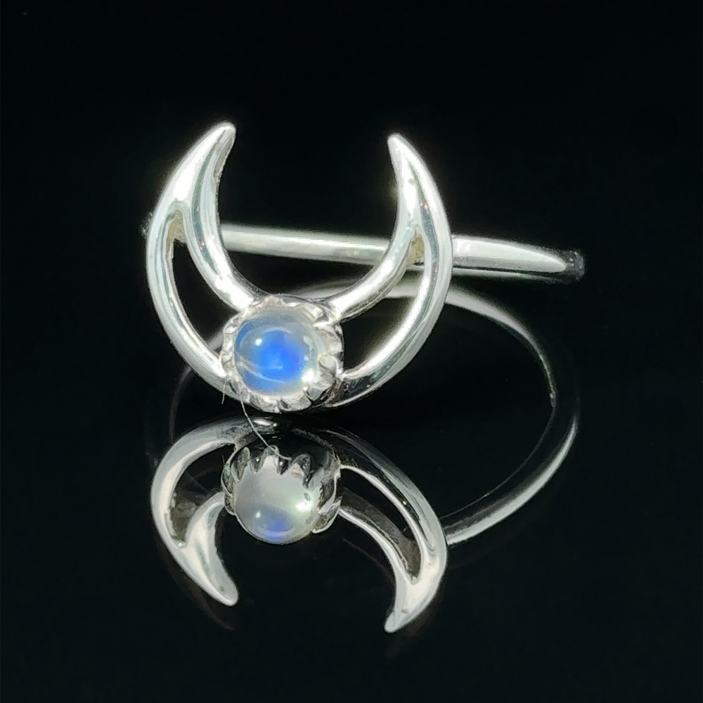 
                  
                    Online Exclusive Gemstone Moon Outline Ring with a moonstone center, reflected on a black surface.
                  
                