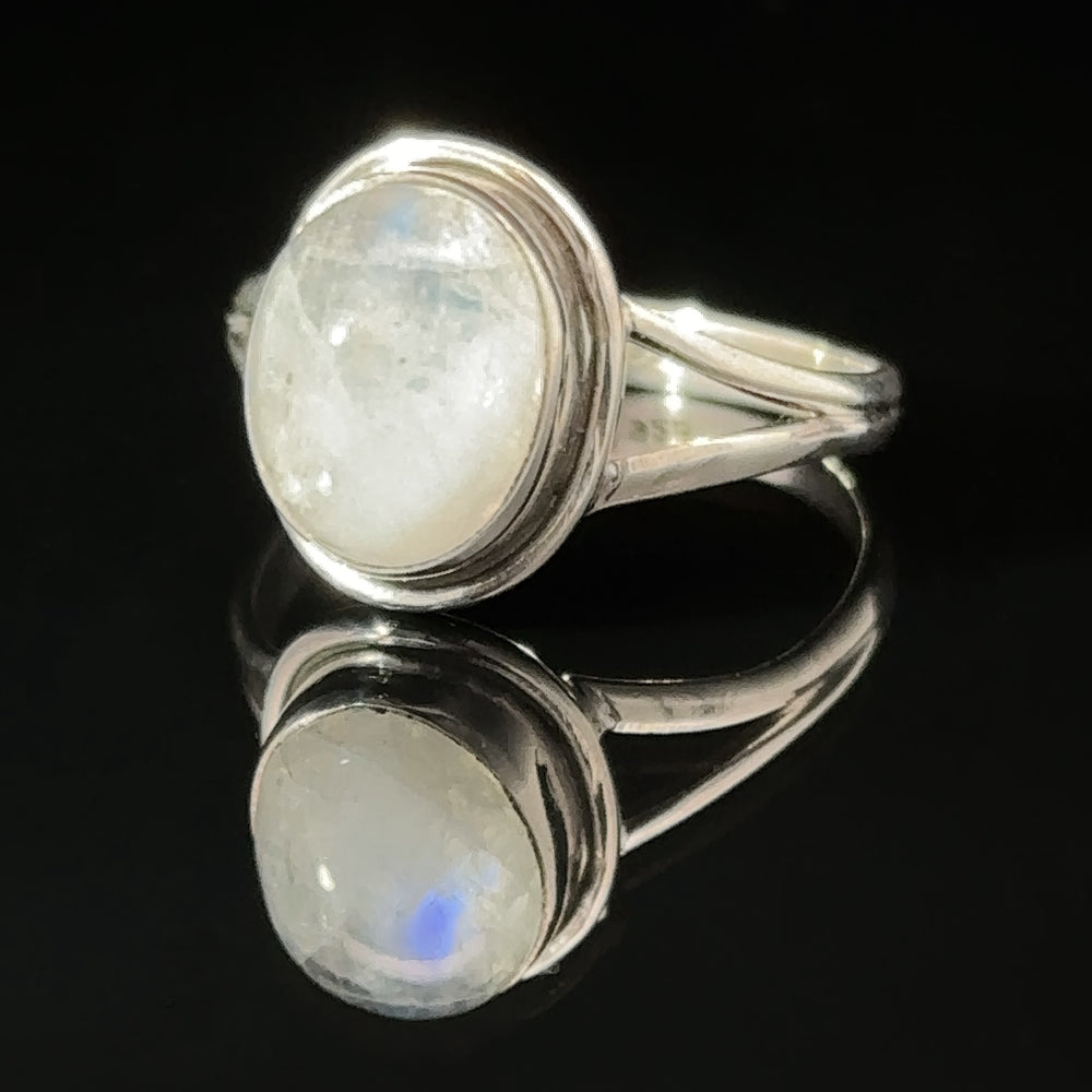 
                  
                    A sterling silver Oval Split Shank Stone Ring with an oval moonstone set on a reflective surface.
                  
                