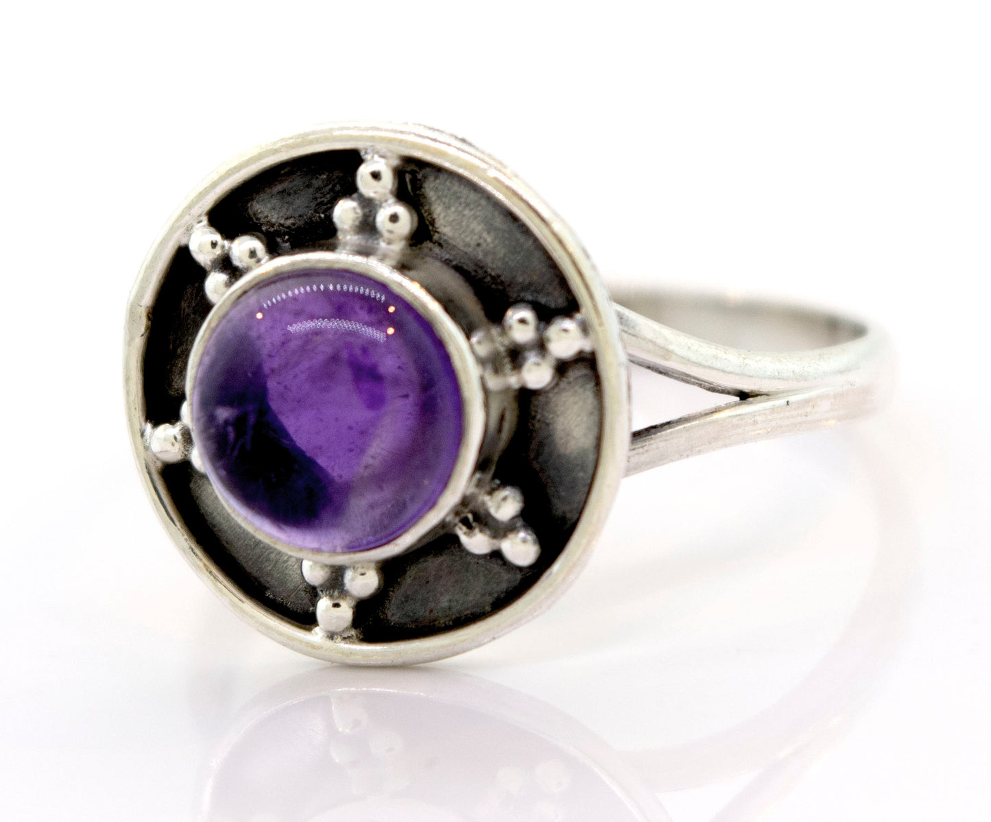 
                  
                    Gemstone Ring With Unique Oxidized Design featuring a round purple gemstone set in an ornate circular bezel with small decorative silver beads, crafted from oxidized sterling silver for a vintage touch.
                  
                