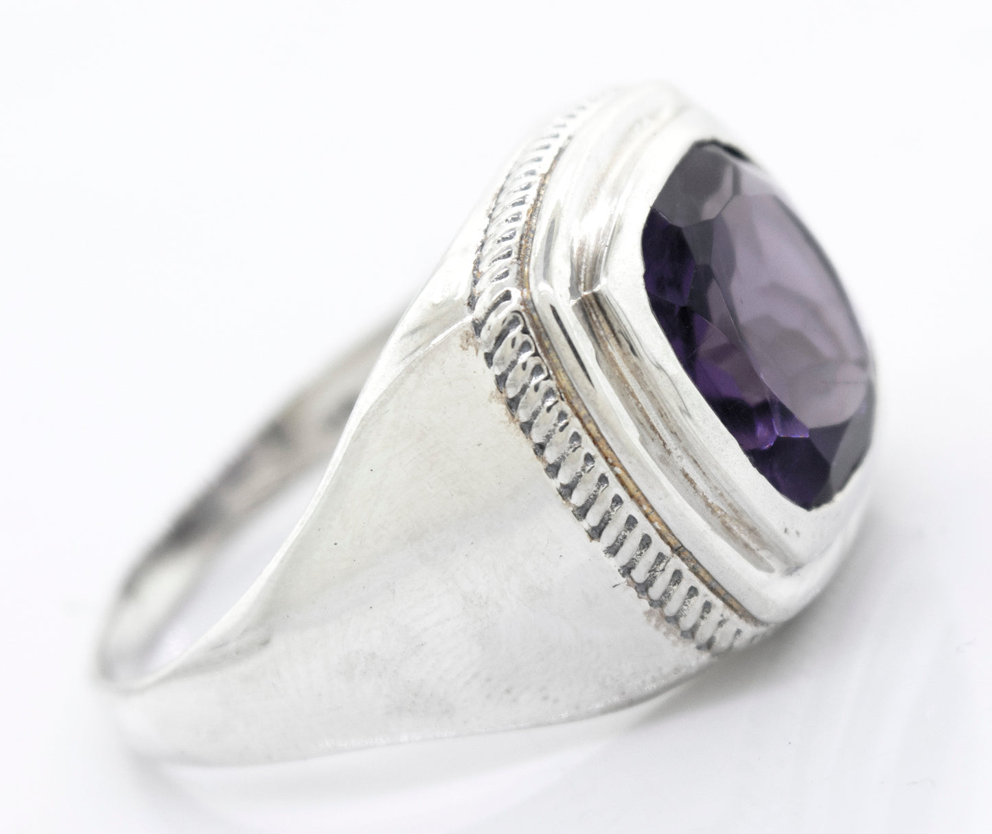 
                  
                    A Faceted Stone Signet Ring with a large oval-shaped amethyst gemstone set in a raised bezel on a white background.
                  
                