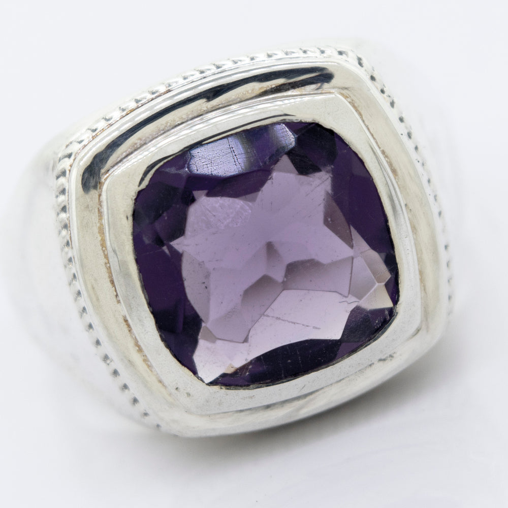 
                  
                    A Faceted Stone Signet Ring with a large, square-cut Amethyst gemstone set in the center.
                  
                