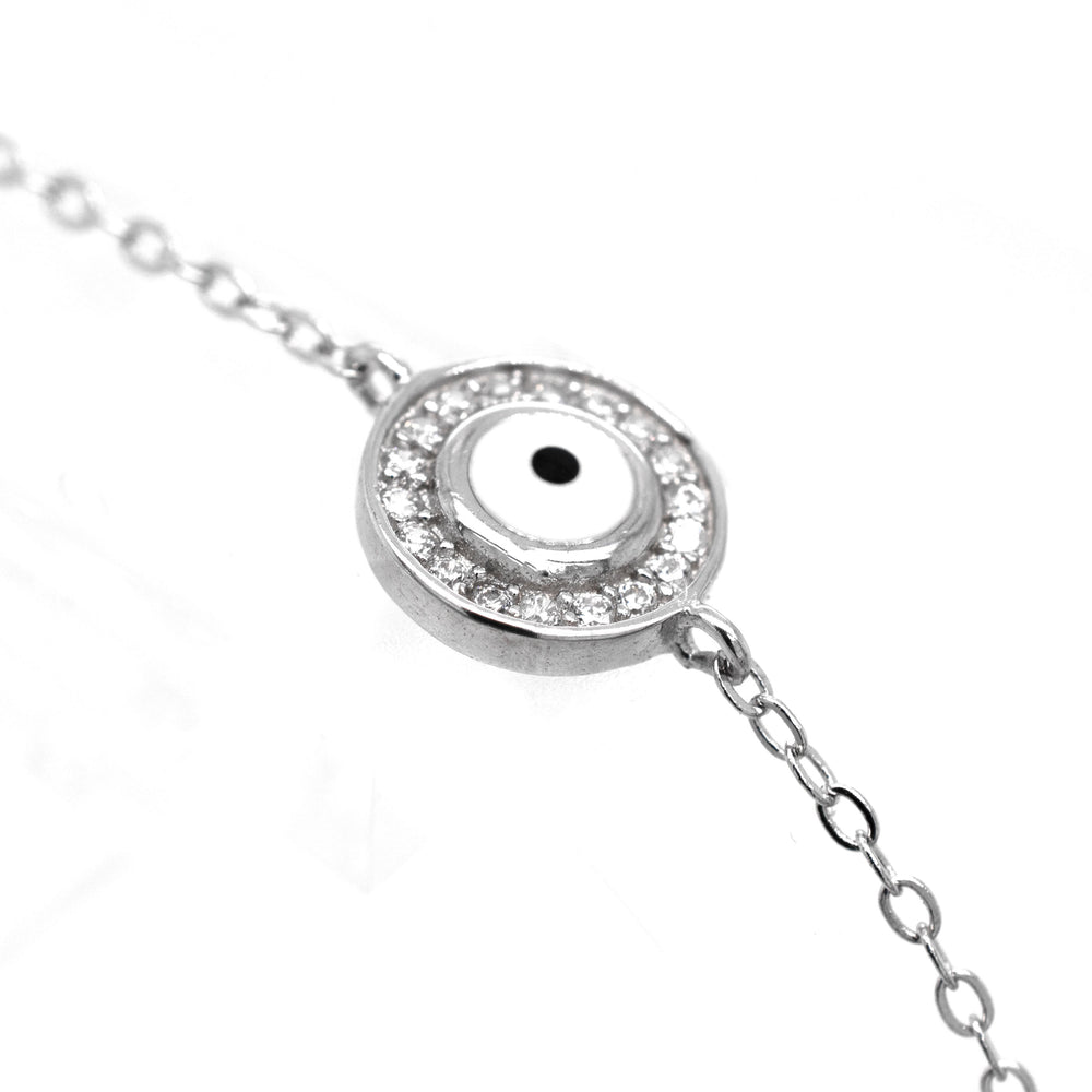 Close-up of a Delicate Cubic Zirconia Evil Eye Bracelet featuring an eye-like design within a circular pendant, surrounded by small, clear Cubic Zirconia gemstones.