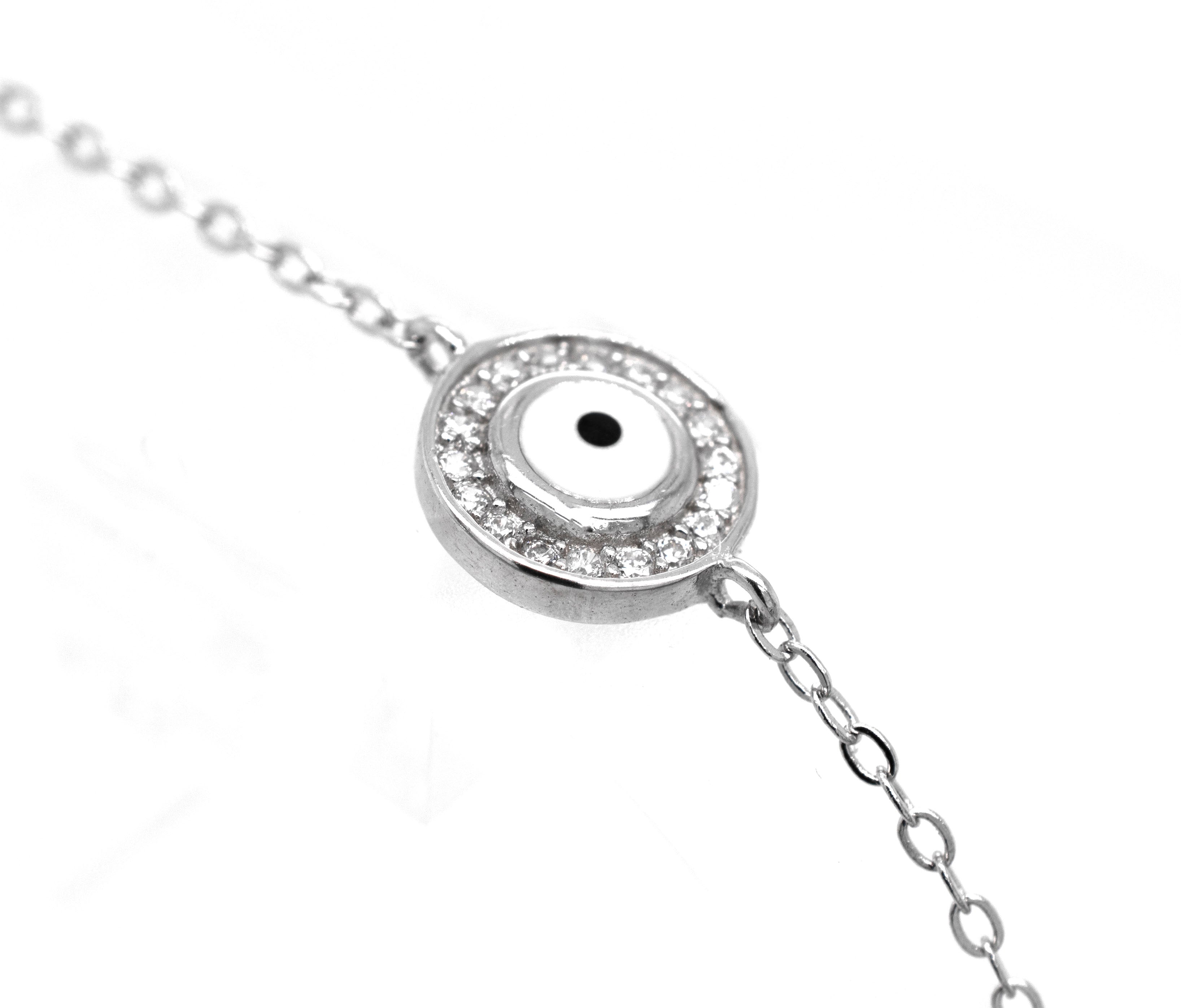 Close-up of a Delicate Cubic Zirconia Evil Eye Bracelet featuring an eye-like design within a circular pendant, surrounded by small, clear Cubic Zirconia gemstones.