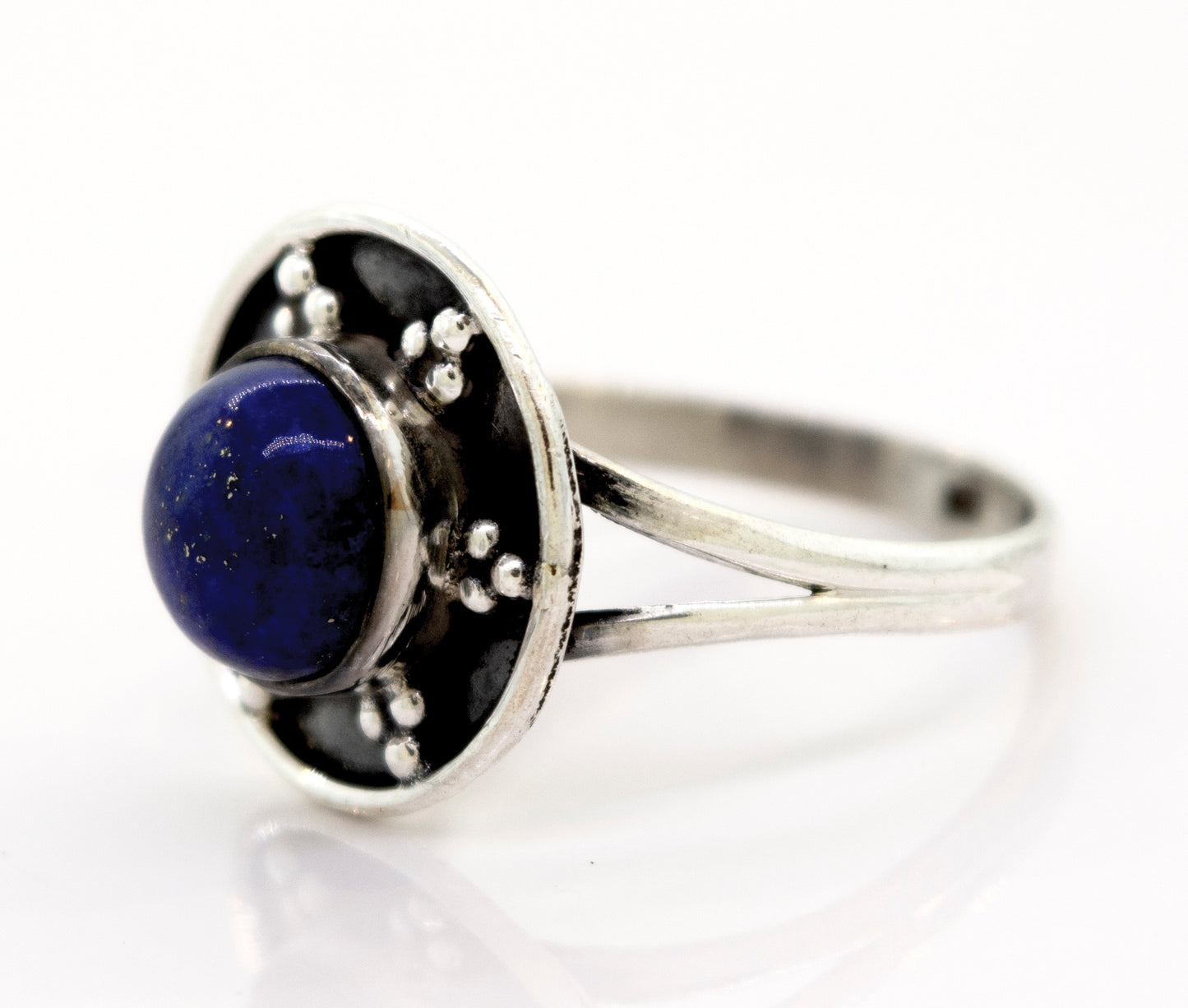 
                  
                    A Gemstone Ring With Unique Oxidized Design featuring a round, dark blue gemstone set in an ornate circular setting with small decorative oxidized silver beads.
                  
                