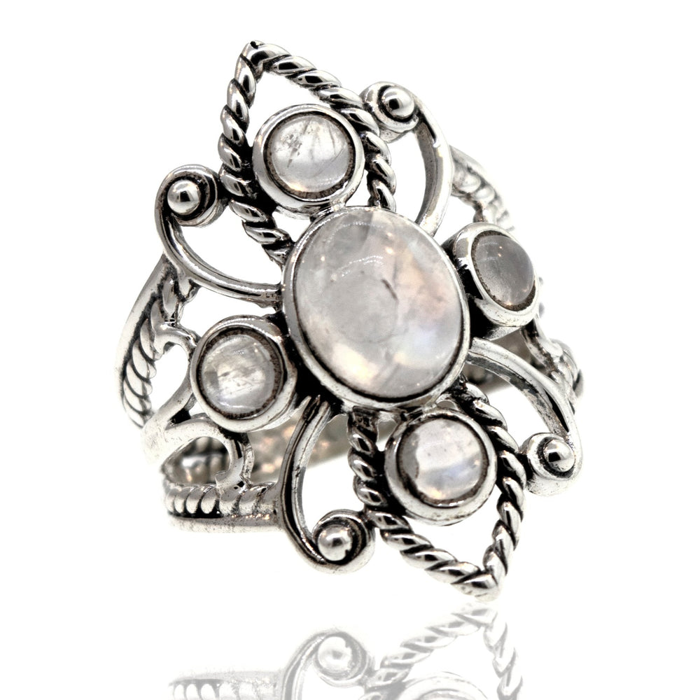 
                  
                    Online Only Exclusive Multistone Ring with a central moonstone and smaller surrounding carnelian stones, displayed against a white background with a reflection below.
                  
                