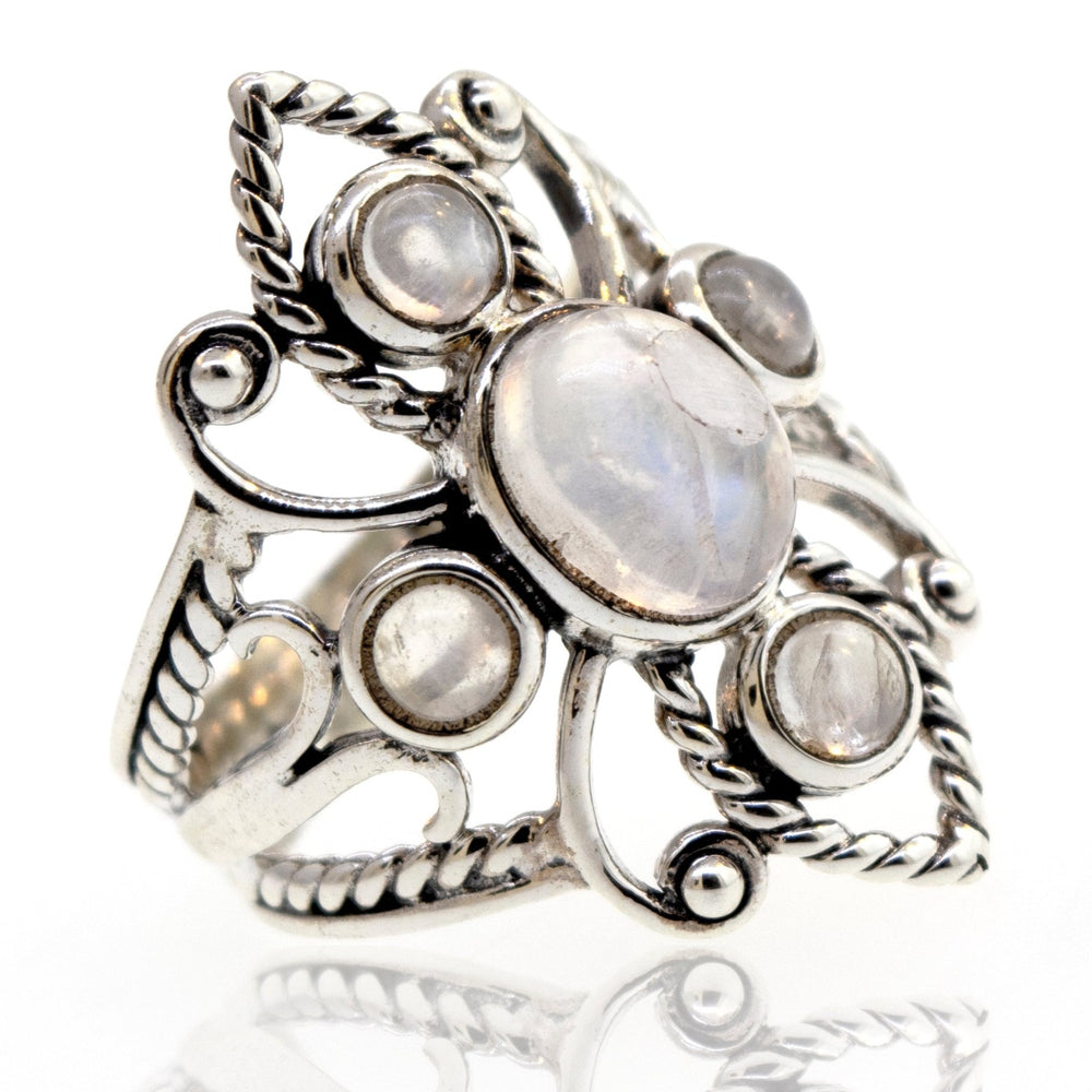 
                  
                    An ornate sterling silver ring featuring multiple moonstones set in an intricate, vintage design with filigree details.
                  
                