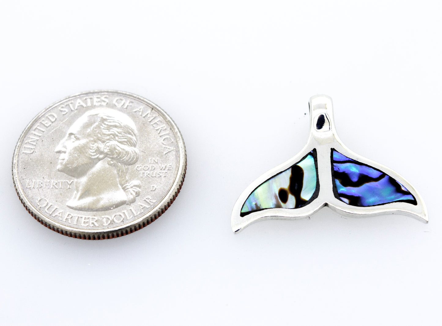 
                  
                    A Super Silver inlay whale tail pendant next to a quarter.
                  
                