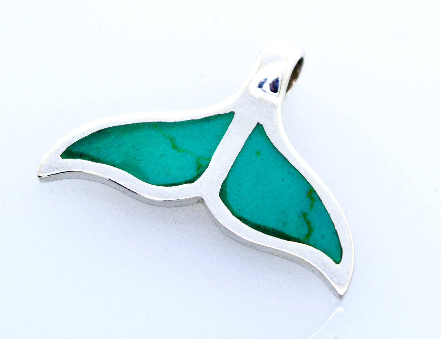 
                  
                    A Super Silver Inlay Whale Tail Pendant adorned with a beautiful green stone, symbolizing both conservation and the elegance of these magnificent creatures.
                  
                