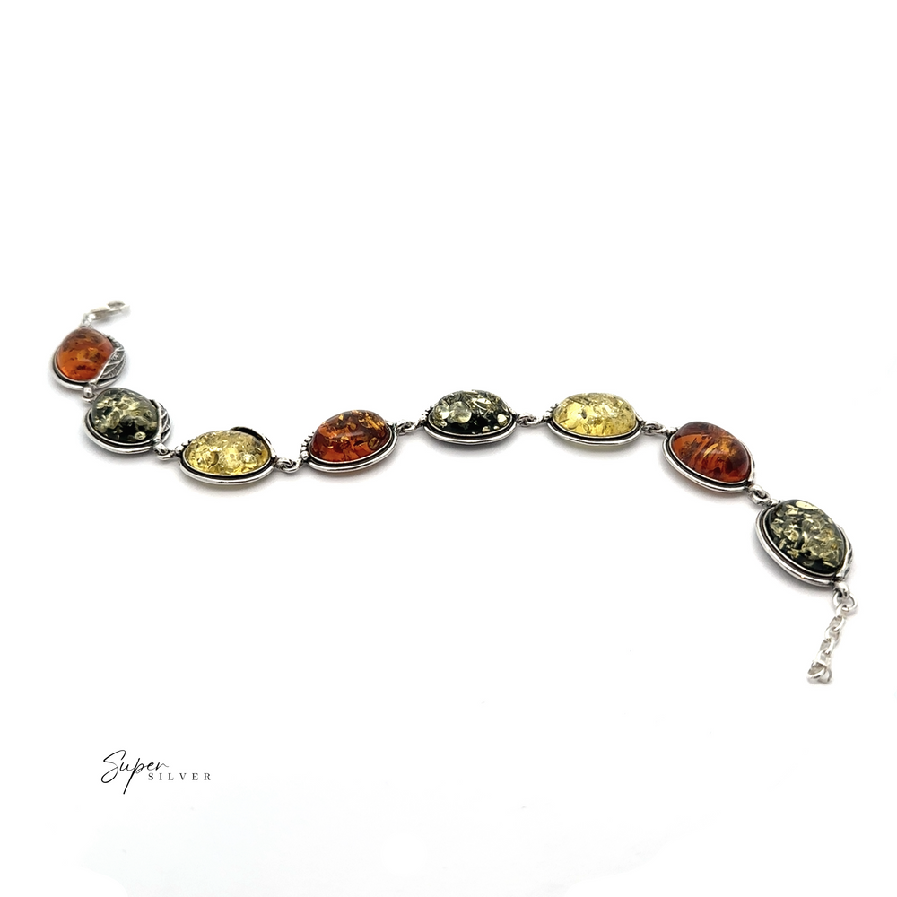 
                  
                    The Oval Amber Link Bracelet with Leaf Detail showcases classic elegance with its multi-colored oval stones set in silver, reminiscent of a Baltic amber bracelet, beautifully arranged on a white background.
                  
                