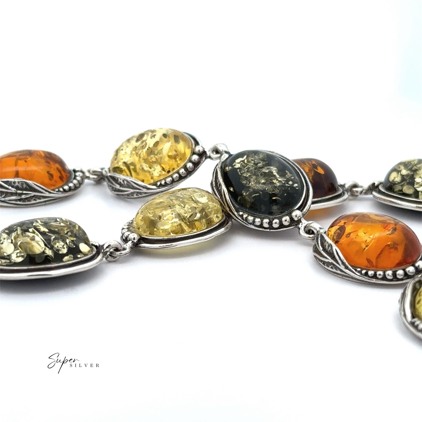 
                  
                    A detailed view of the Oval Amber Link Bracelet With Leaf Detail, showcasing its vintage charm with silver accents and adorned with oval Baltic amber stones in diverse hues of yellow and orange.
                  
                