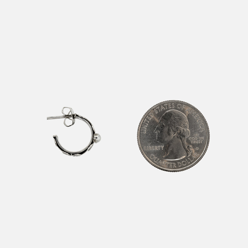 A sterling silver coin next to Super Silver's Pearl Stud Hoop with Stud earrings.